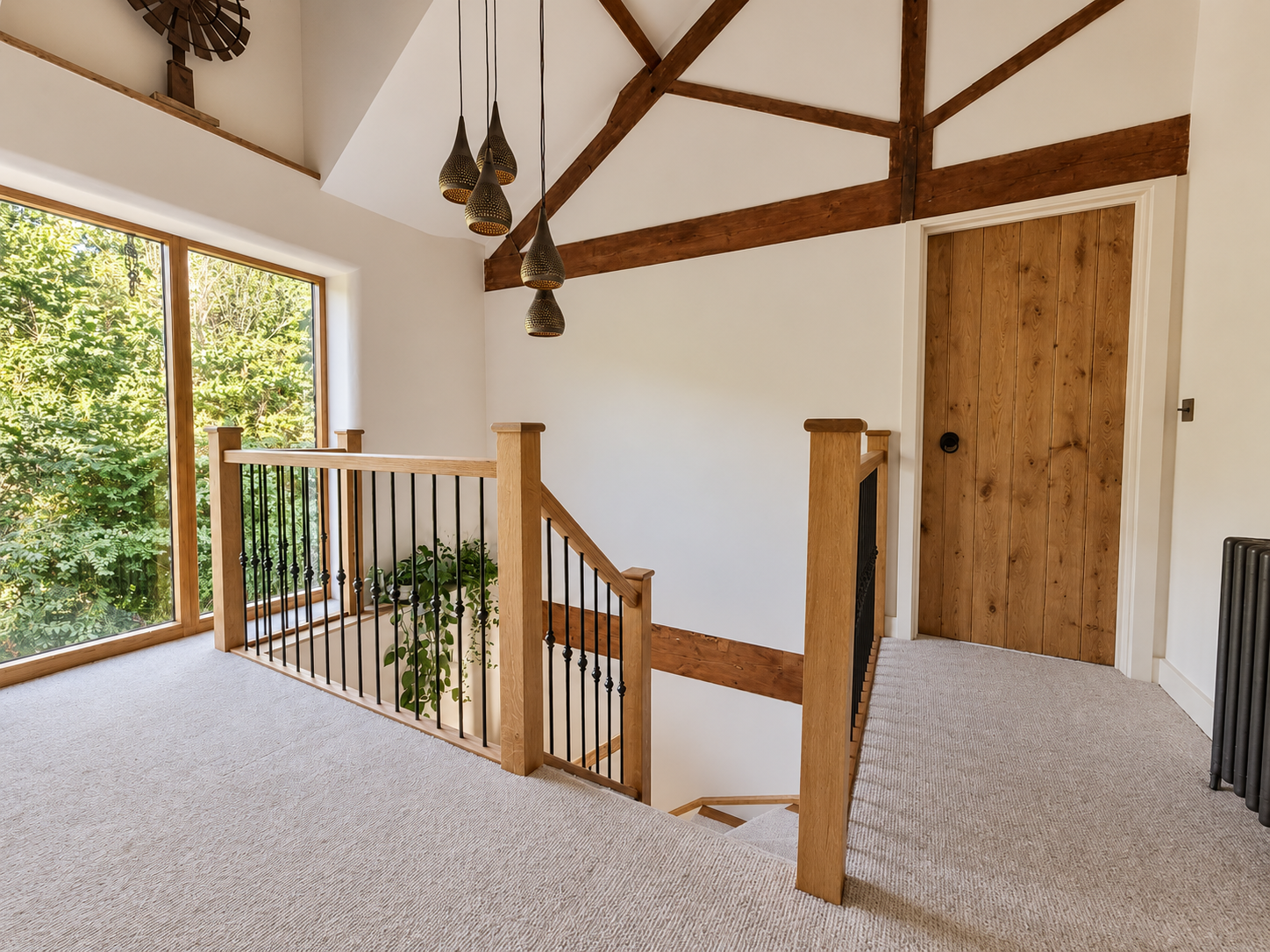 Daylight across the oak landing, original roof trusses and pendant lights