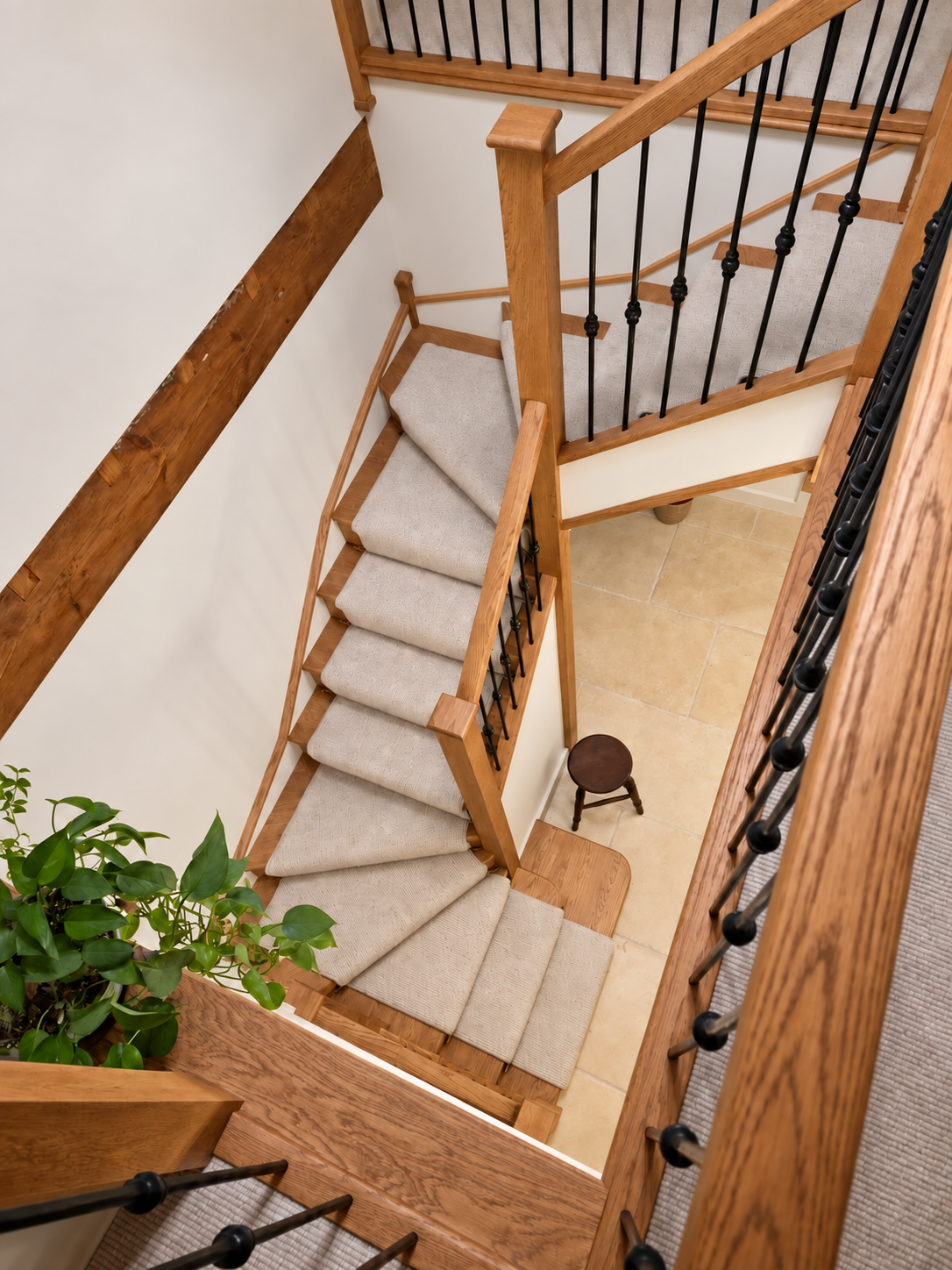 Overhead view down the winding oak staircase to the limestone hall